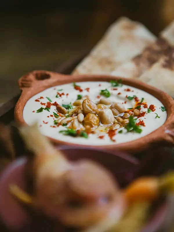 Houmous maison et pain chaud, filet d'huile d'olive