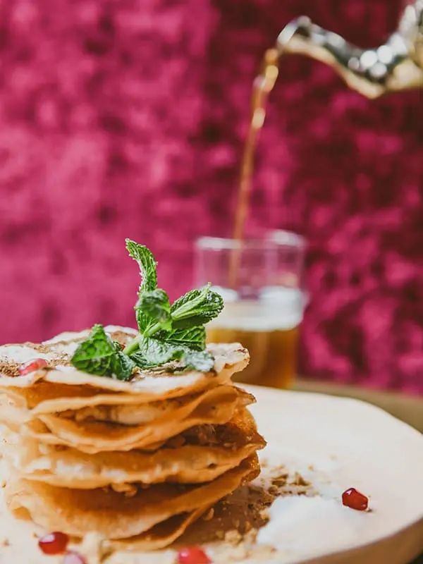 Beignets sfinges empilés et thé à la menthe versé
